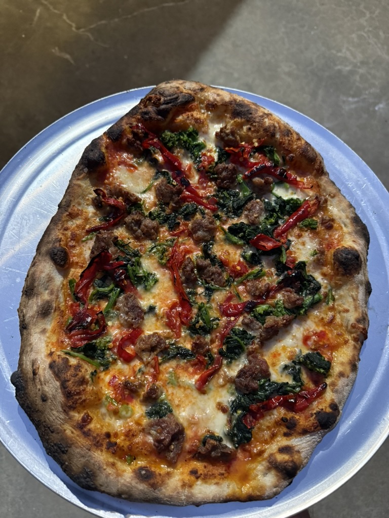 Jimmy Nardello pepper and sausage pizza on a blue plate