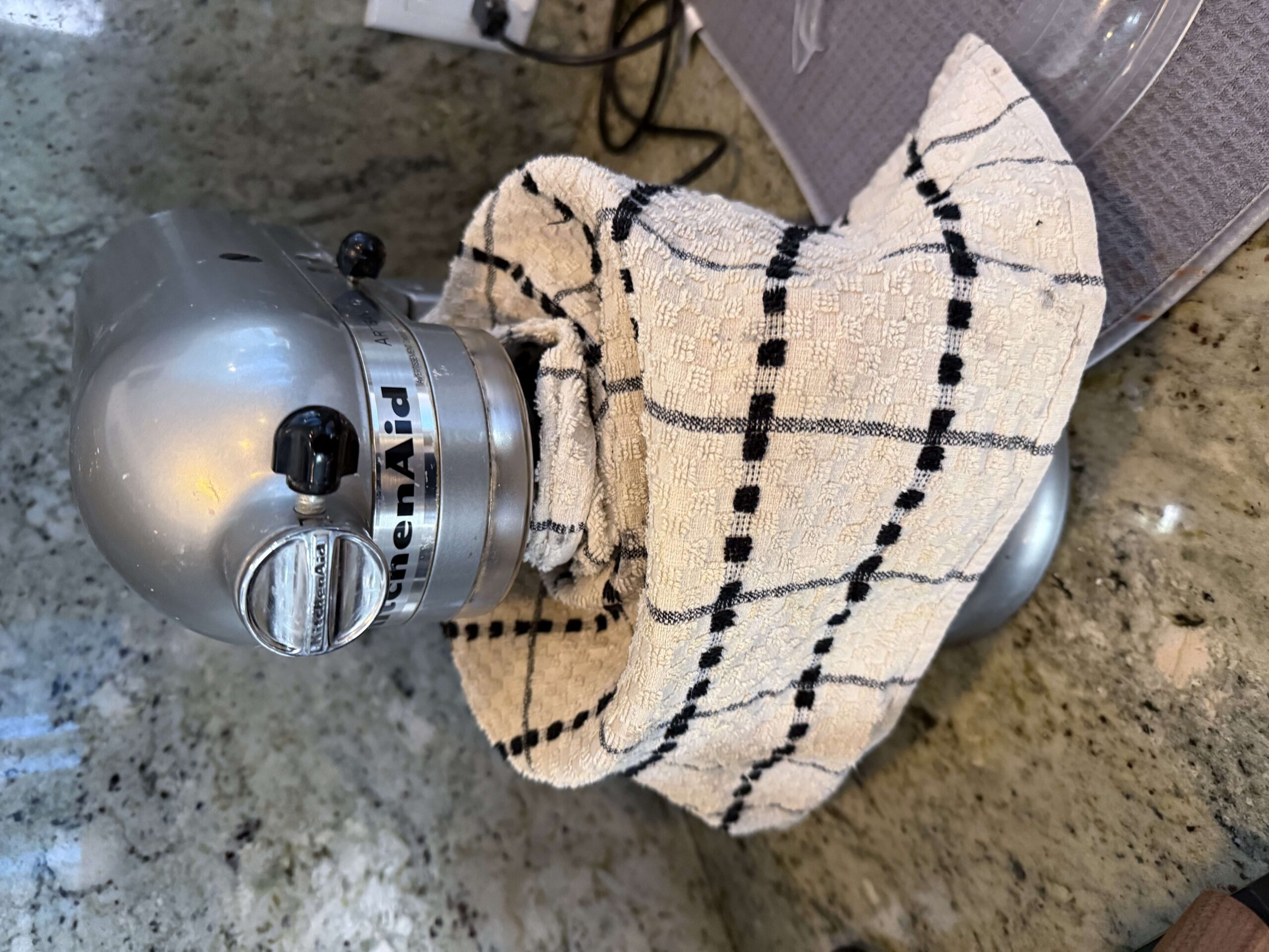KitchenAid stand mixer covered with a kitchen towel during autolyse